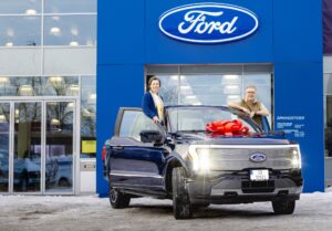 Blue ford car with couple standing on door