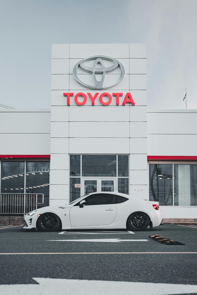 White Toyota car in front of Toyota company